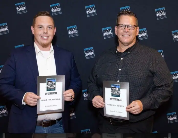 Two men stand side by side, each holding a "Winner" certificate for Shane Fisk Roofing at a 2024 Choice Awards event, with a branded backdrop behind them.